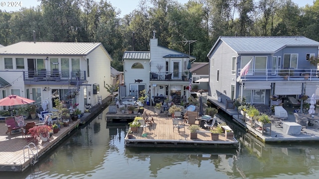 view of dock featuring a balcony, a water view, and a patio