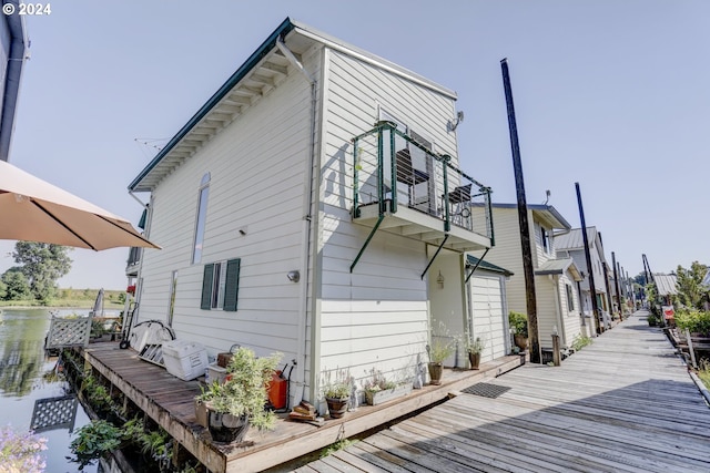 view of side of property with a balcony and a water view