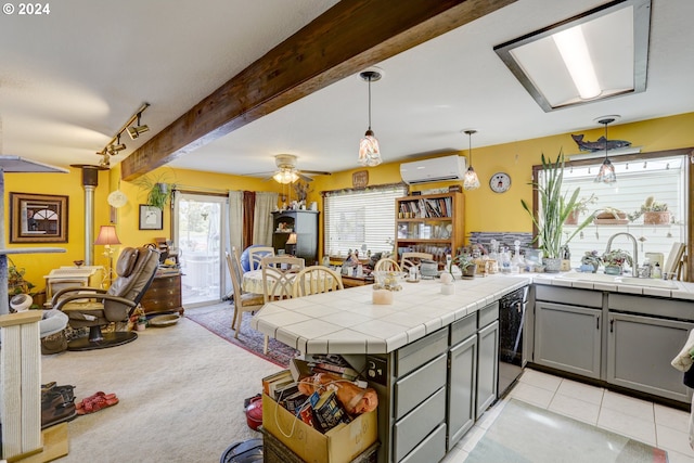 kitchen with tile counters, plenty of natural light, ceiling fan, and gray cabinets