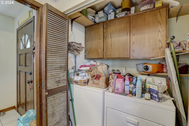 washroom featuring cabinets, washer and clothes dryer, and light tile patterned floors