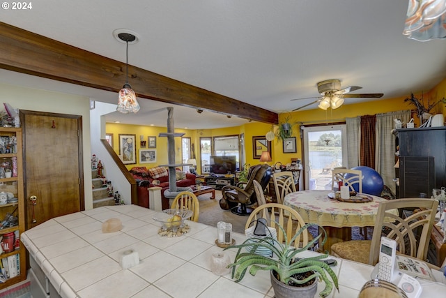 tiled dining space featuring beam ceiling and ceiling fan