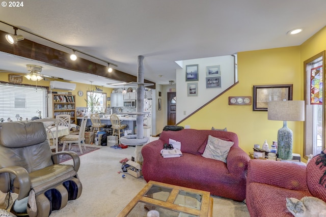 living room featuring track lighting, a wall mounted AC, a textured ceiling, ceiling fan, and carpet flooring