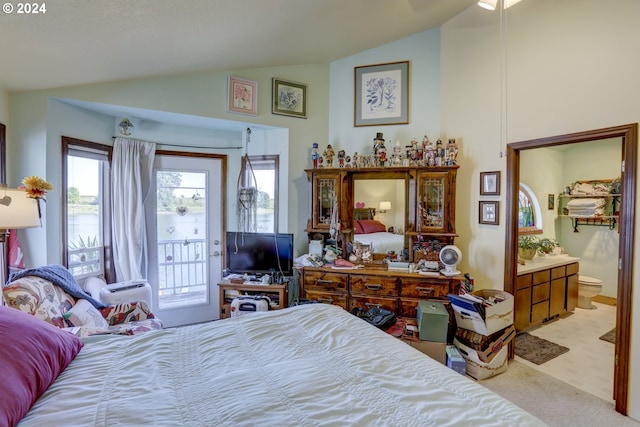 bedroom with light carpet, vaulted ceiling, and connected bathroom