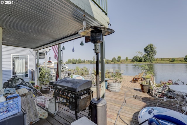 deck with a water view and area for grilling