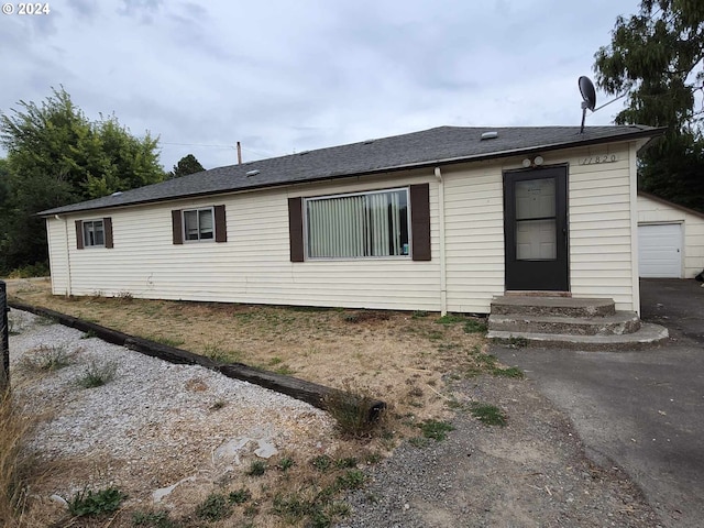 view of front of home featuring a garage and an outbuilding