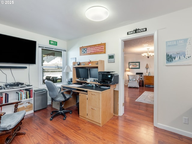 office with baseboards, light wood finished floors, and a chandelier