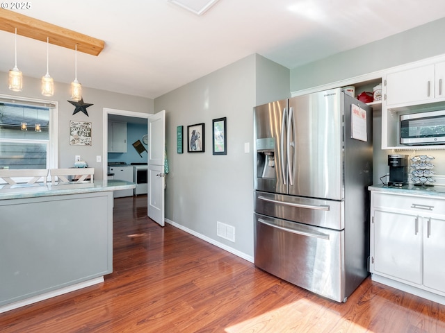 kitchen featuring appliances with stainless steel finishes, white cabinetry, decorative light fixtures, wood finished floors, and visible vents