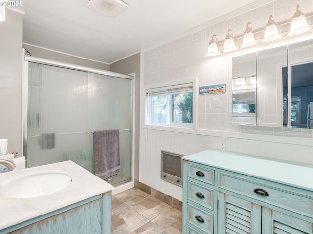 bathroom featuring vanity, crown molding, heating unit, and a stall shower