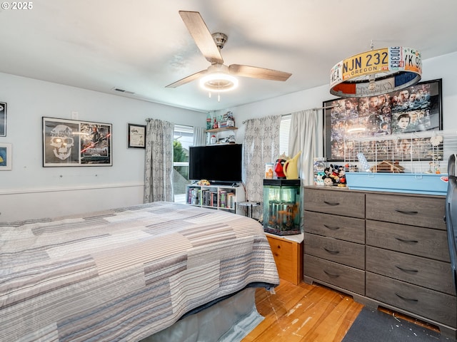 bedroom with visible vents, ceiling fan, and wood finished floors