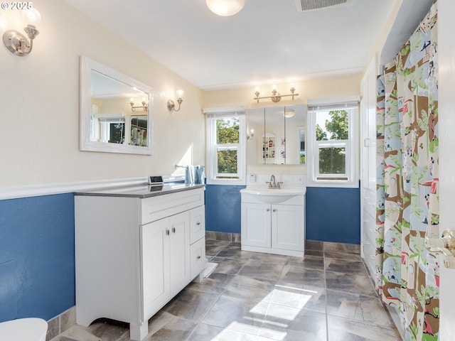 full bathroom with two vanities and a sink