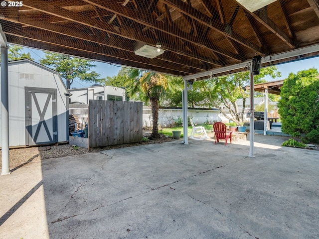 view of patio featuring an outbuilding, fence, and a storage shed