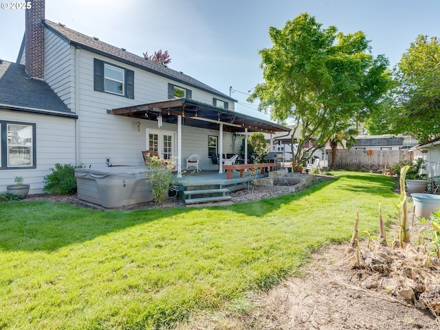 back of property featuring fence, a shingled roof, a wooden deck, a chimney, and a lawn