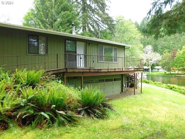 rear view of house with a garage and a yard