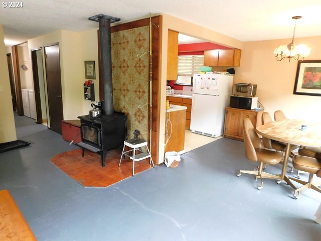 dining area with a chandelier and a wood stove