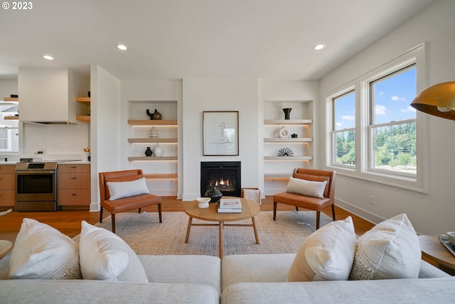 living room with light hardwood / wood-style flooring and built in shelves