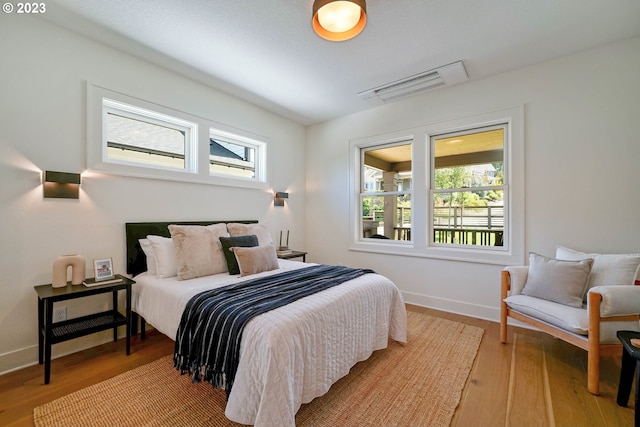 bedroom with wood-type flooring and multiple windows