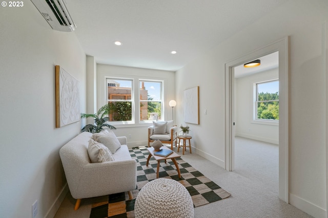 sitting room featuring light carpet and an AC wall unit