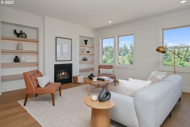 living room featuring hardwood / wood-style flooring, a wealth of natural light, and built in shelves