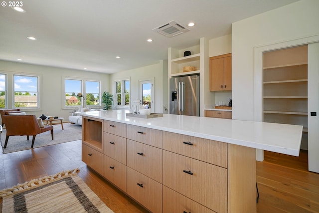 kitchen featuring dark hardwood / wood-style floors, light brown cabinetry, a center island, and high quality fridge