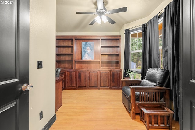 living area featuring light hardwood / wood-style floors and ceiling fan