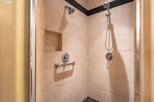 interior details featuring tiled shower