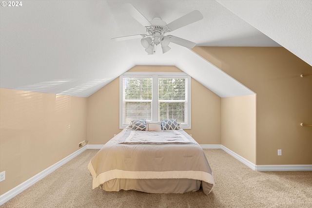 carpeted bedroom featuring ceiling fan, a textured ceiling, and vaulted ceiling