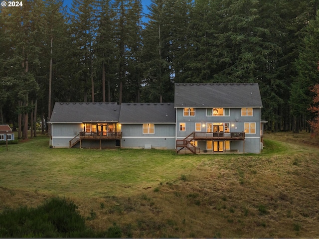 back of house featuring a wooden deck and a lawn