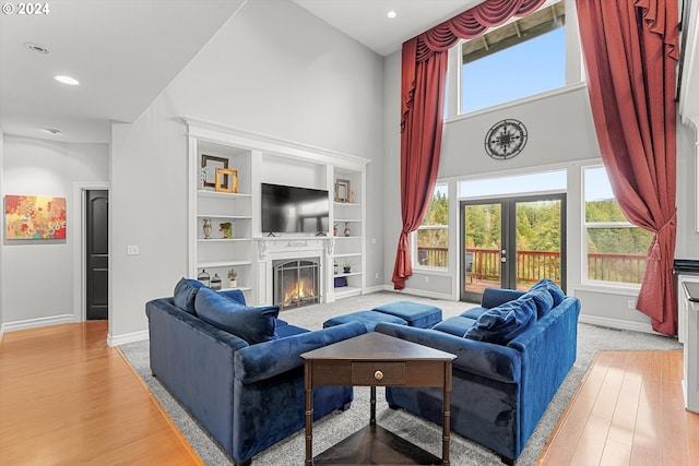 living room featuring french doors, hardwood / wood-style flooring, and a towering ceiling