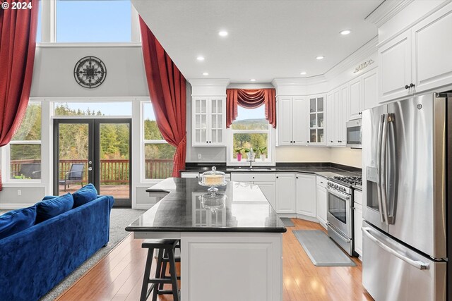 kitchen featuring white cabinetry, stainless steel appliances, a center island, and plenty of natural light