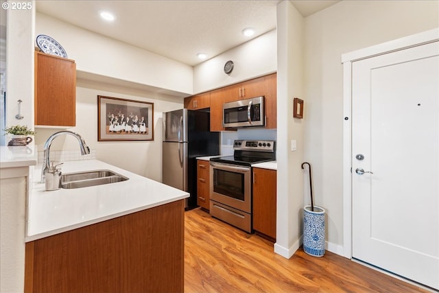 kitchen featuring sink, light hardwood / wood-style floors, and appliances with stainless steel finishes