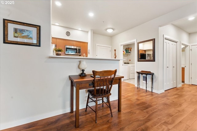 office space featuring washer and dryer and light hardwood / wood-style floors