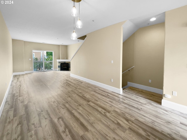 unfurnished living room with lofted ceiling and light hardwood / wood-style floors