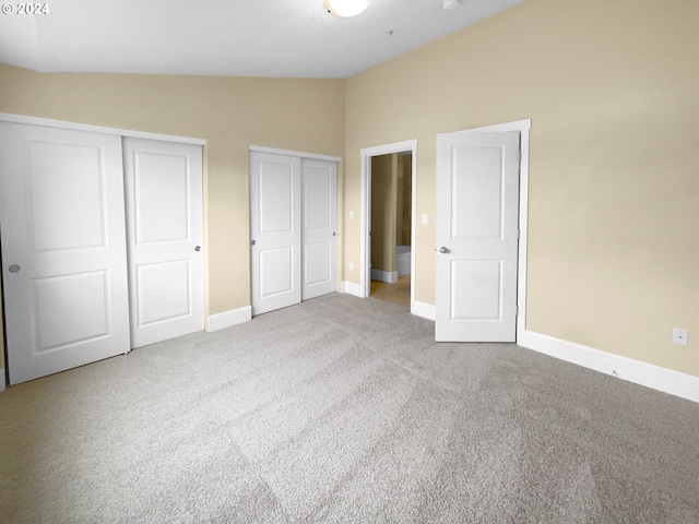 unfurnished bedroom with lofted ceiling and carpet