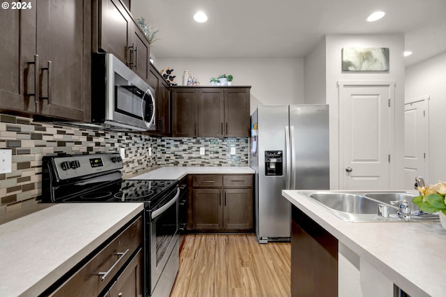 kitchen with dark brown cabinetry, sink, backsplash, light wood-type flooring, and appliances with stainless steel finishes