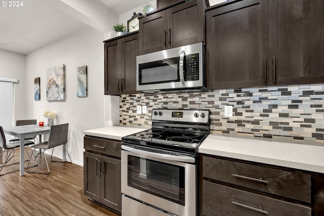 kitchen with appliances with stainless steel finishes, light countertops, dark brown cabinetry, and backsplash