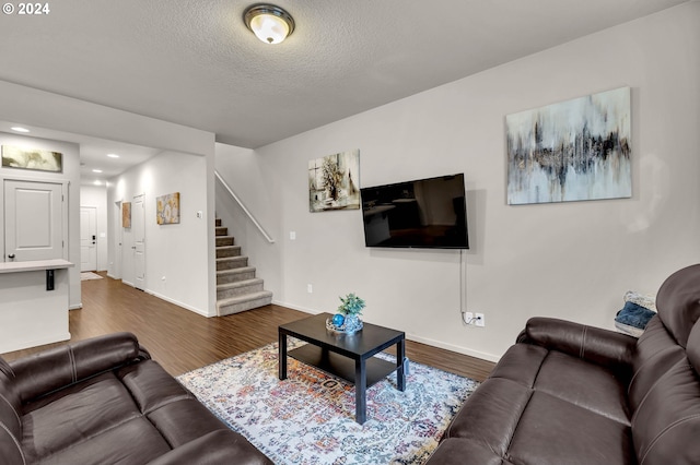 living area featuring a textured ceiling, recessed lighting, baseboards, stairway, and dark wood-style floors