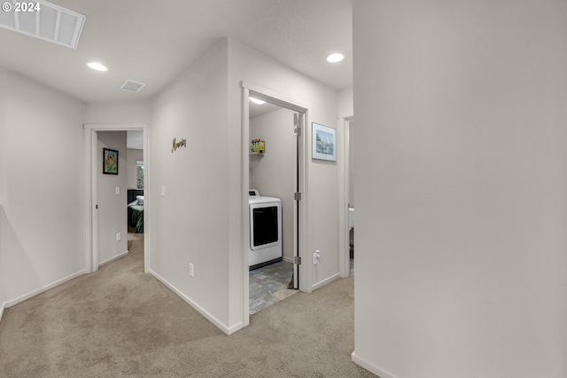 hallway featuring light colored carpet and washer / clothes dryer