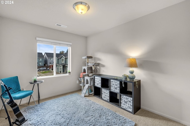 living area with carpet flooring, visible vents, and baseboards