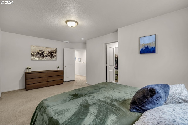 bedroom featuring a textured ceiling and light carpet