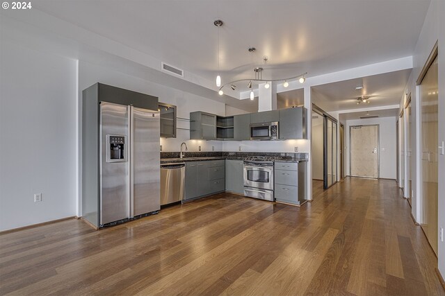 kitchen featuring track lighting, stainless steel appliances, and hardwood / wood-style flooring