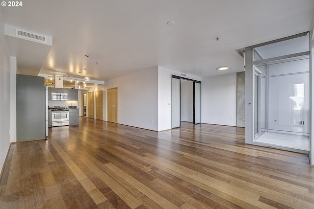 unfurnished living room featuring wood-type flooring and a barn door