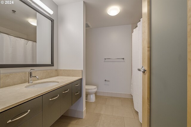 bathroom featuring tile patterned flooring, toilet, and vanity