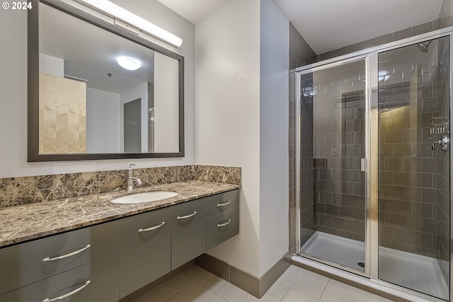 bathroom with tile patterned flooring, a shower with door, and vanity