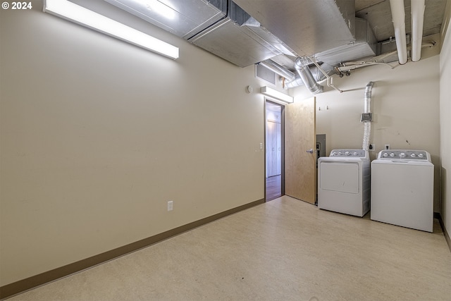 basement with washing machine and clothes dryer and electric panel