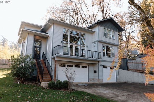 back of house with a garage, a yard, and a balcony