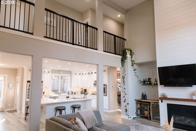 living room with light wood-type flooring and a towering ceiling