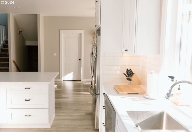 kitchen featuring sink, stainless steel appliances, white cabinets, and tasteful backsplash