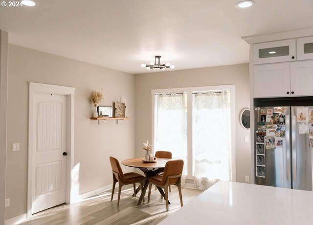 dining area with a chandelier and light hardwood / wood-style flooring