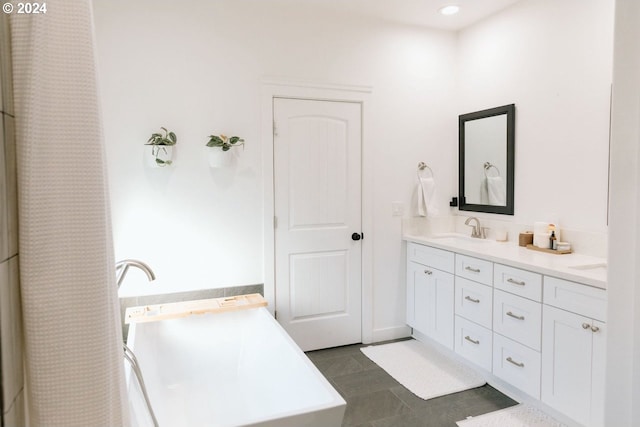 bathroom featuring tile patterned floors, vanity, and a tub to relax in