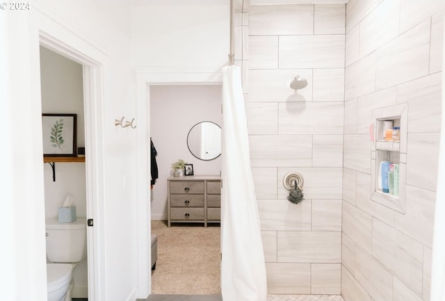 bathroom with toilet and a tile shower